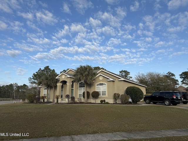 view of front facade with stucco siding and a front yard