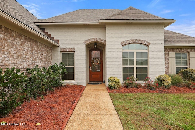 entrance to property featuring a lawn