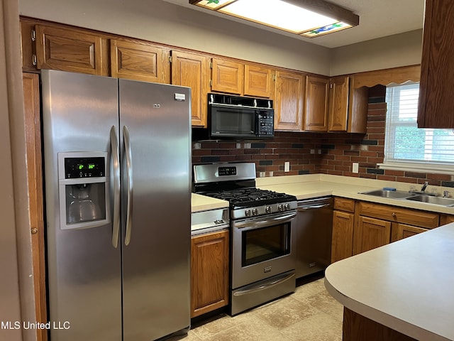 2 Concord Pl, Gulfport, MS 39507 - kitchen featuring stainless steel appliances, decorative backsplash, light countertops, and brown cabinets