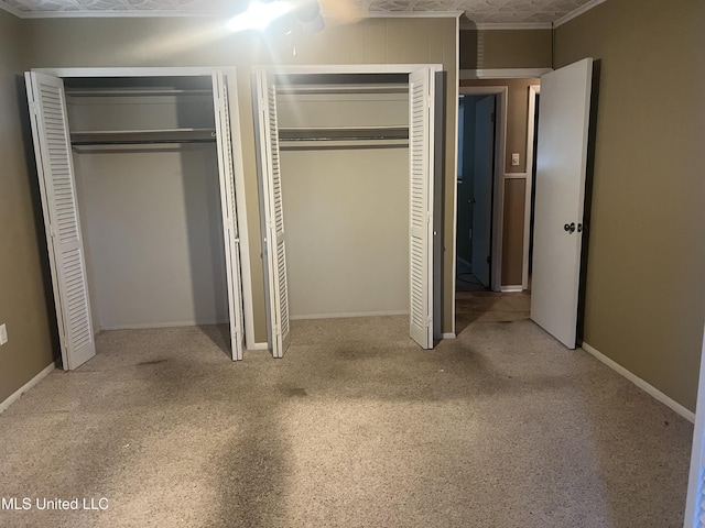 2 Concord Pl, Gulfport, MS 39507 - unfurnished bedroom featuring multiple closets, carpet, and crown molding