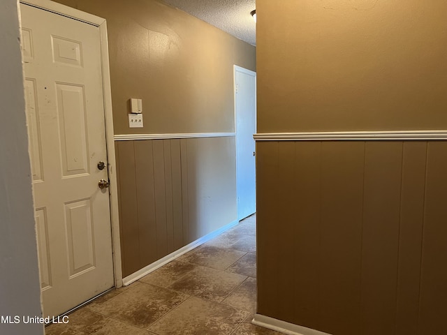 2 Concord Pl, Gulfport, MS 39507 - hall featuring a textured ceiling, a wainscoted wall, and dark stone finish floors