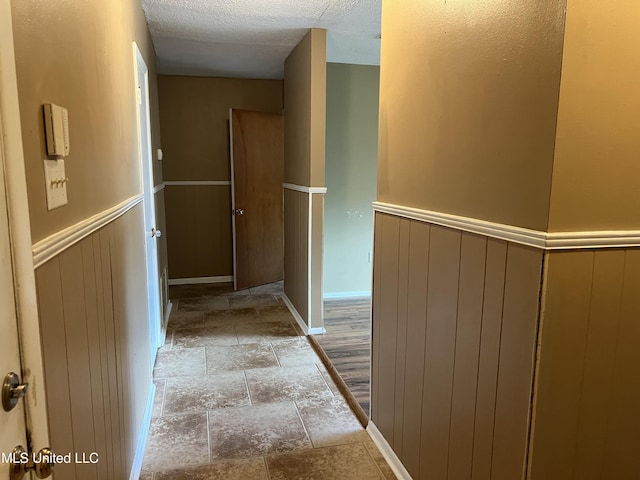 2 Concord Pl, Gulfport, MS 39507 - corridor with stone tile flooring, a wainscoted wall, and a textured ceiling