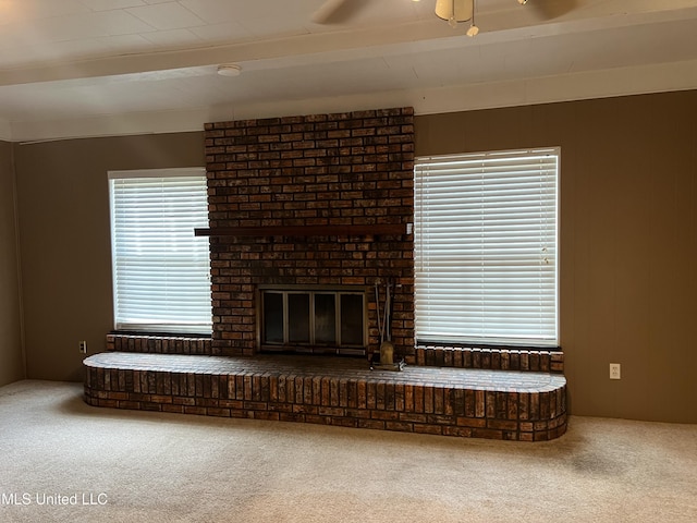 2 Concord Pl, Gulfport, MS 39507 - unfurnished living room featuring carpet flooring, ceiling fan, a fireplace, and beamed ceiling