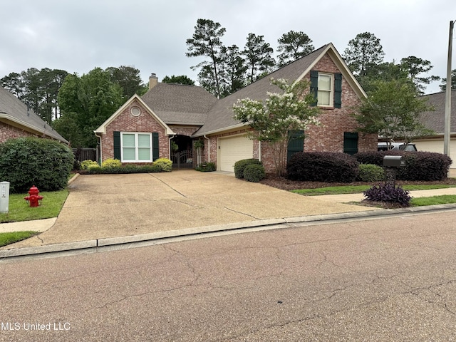 771 Versailles Dr, Ridgeland, MS 39157 - traditional-style house featuring brick siding, an attached garage, a chimney, and driveway