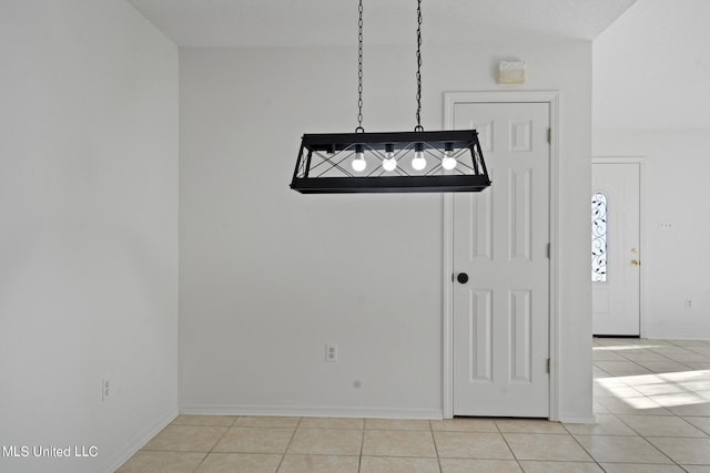 unfurnished dining area with a textured ceiling and light tile patterned floors