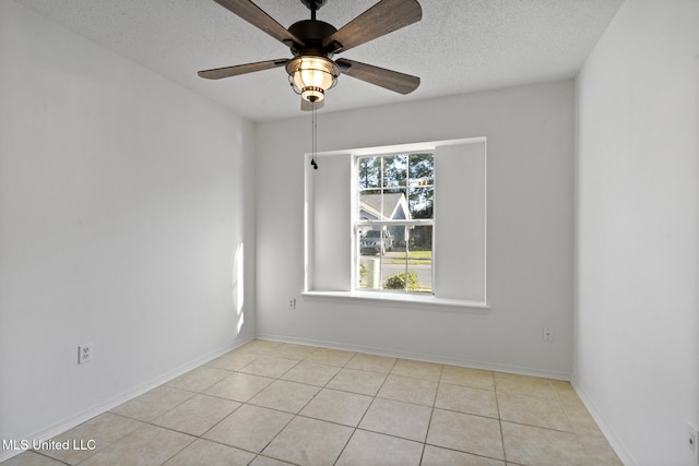 tiled spare room featuring a textured ceiling and ceiling fan