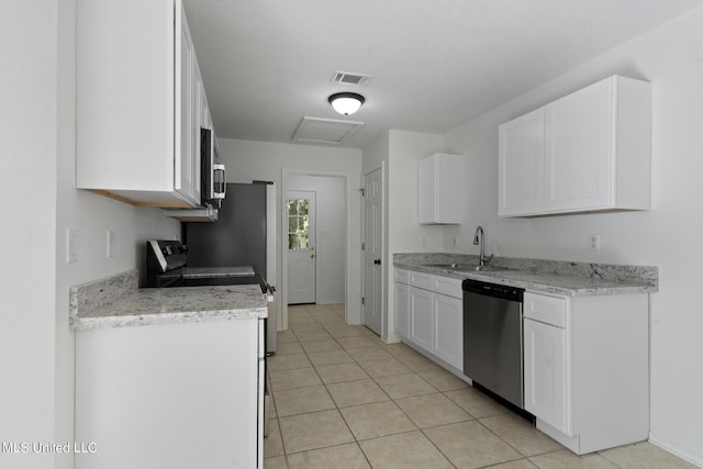 kitchen featuring sink, light stone countertops, white cabinetry, light tile patterned floors, and appliances with stainless steel finishes