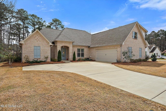 view of front facade featuring brick siding, roof with shingles, concrete driveway, a garage, and a front lawn