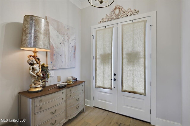 foyer featuring light wood-type flooring, french doors, and baseboards