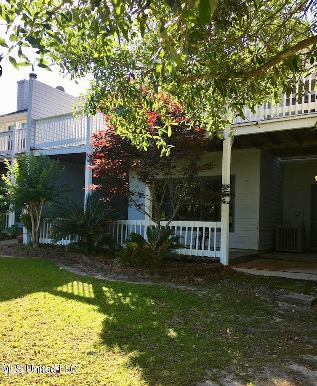 8102 Fairway Villa Dr, Gautier, MS 39553 - view of side of home with a balcony, a lawn, and a porch