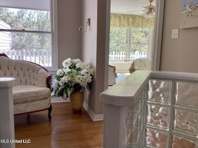 8102 Fairway Villa Dr, Gautier, MS 39553 - sitting room with wood finished floors, ceiling fan, and plenty of natural light