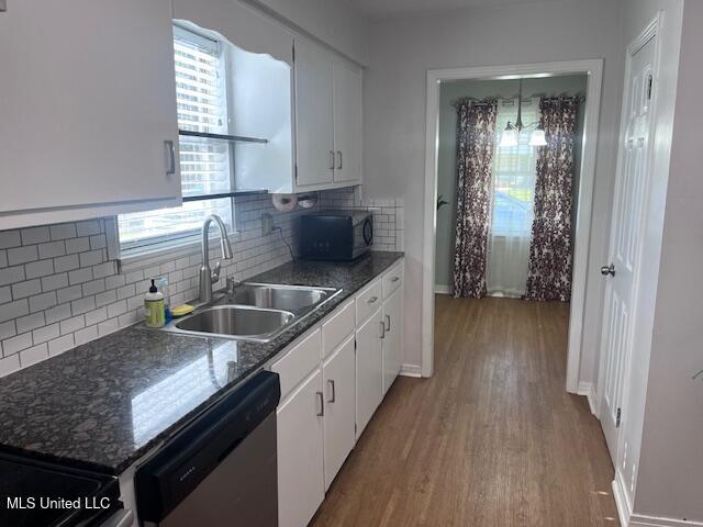 kitchen with stainless steel dishwasher, a sink, wood finished floors, and black microwave