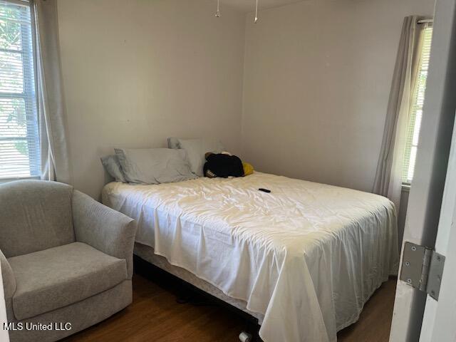 bedroom featuring wood finished floors and multiple windows
