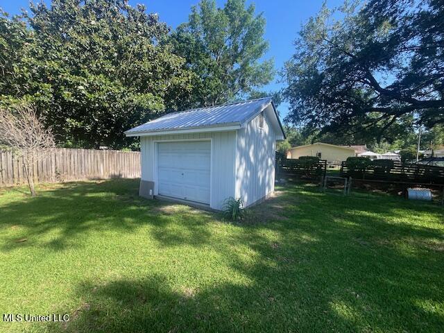 detached garage featuring fence
