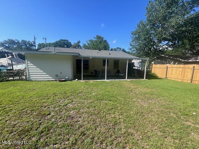 back of property featuring a patio, fence, and a yard