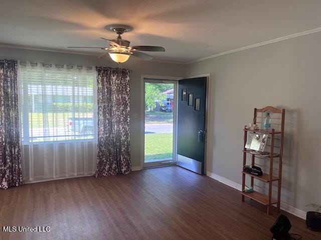 empty room with crown molding, baseboards, a ceiling fan, and wood finished floors