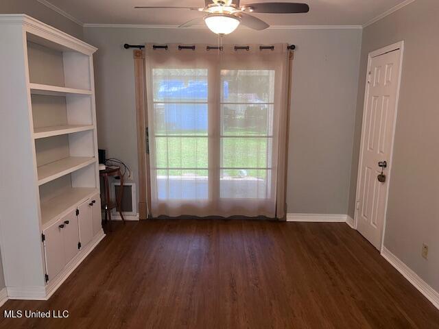 interior space featuring ceiling fan, dark wood finished floors, ornamental molding, and baseboards