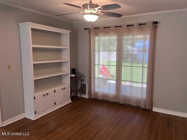 unfurnished room featuring baseboards, ornamental molding, a ceiling fan, and dark wood-style floors