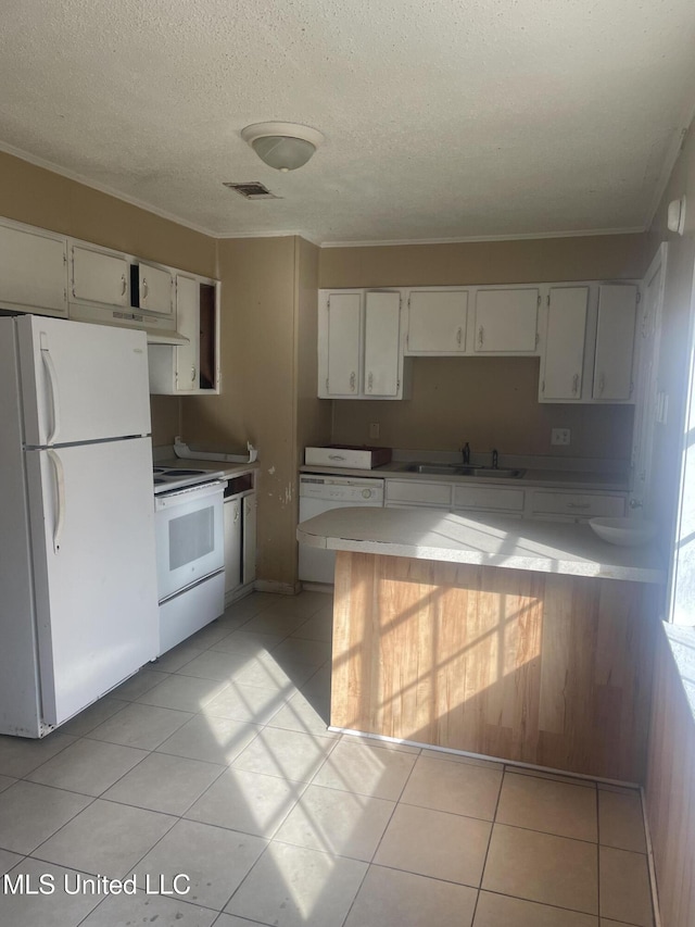 kitchen featuring visible vents, white appliances, crown molding, and a sink