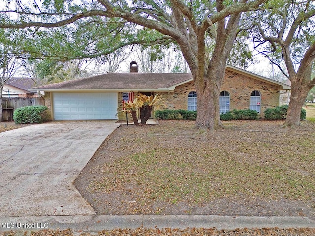 ranch-style house featuring brick siding, a chimney, fence, a garage, and driveway