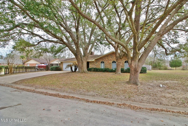 view of front of house featuring a garage, driveway, brick siding, and fence