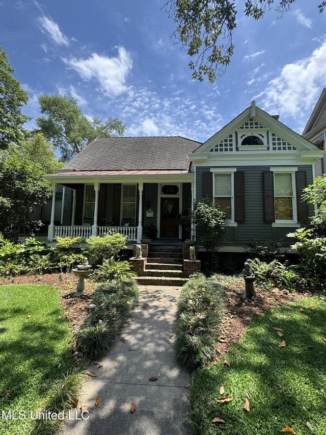view of front of property featuring roof with shingles and covered porch