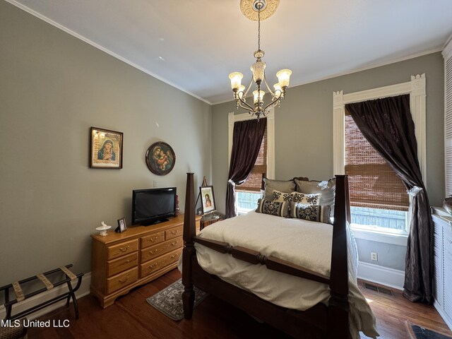 bedroom with crown molding, visible vents, baseboards, dark wood-type flooring, and a notable chandelier