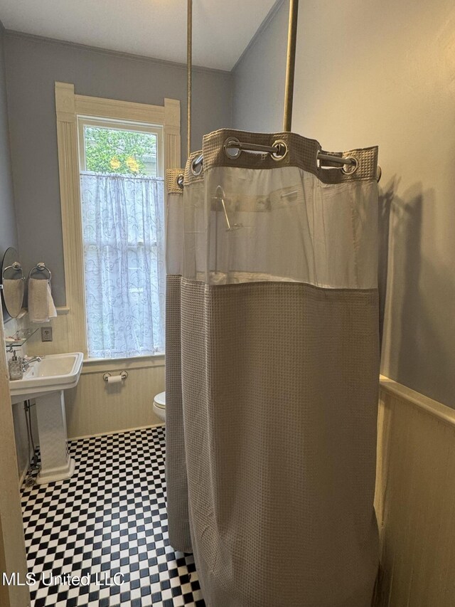 full bathroom with tile patterned floors, toilet, and curtained shower