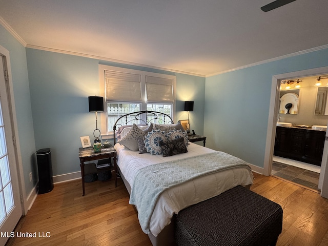 bedroom with baseboards, ornamental molding, wood finished floors, and connected bathroom
