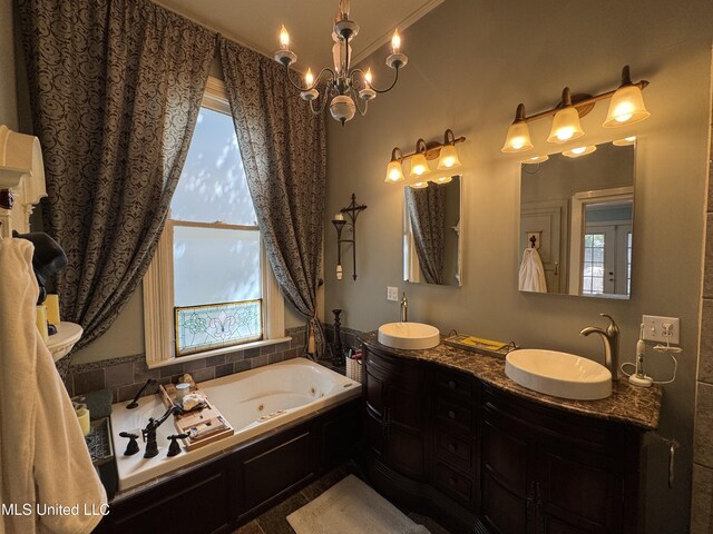 bathroom with a whirlpool tub, a healthy amount of sunlight, and a sink