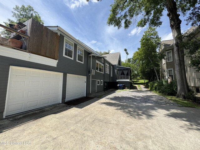 view of side of property with concrete driveway and an attached garage