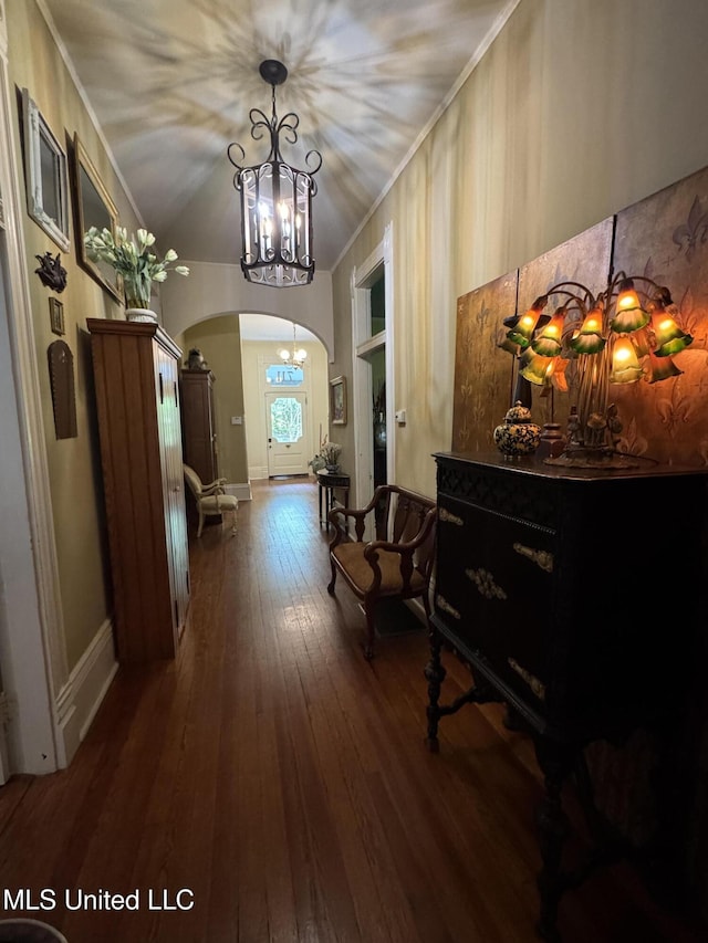 hall featuring an inviting chandelier, arched walkways, crown molding, and hardwood / wood-style floors