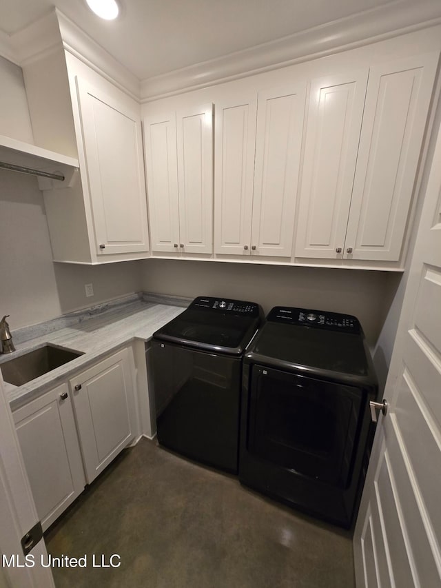 washroom with cabinets, sink, and washer and clothes dryer