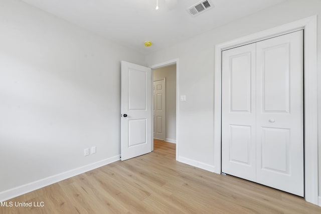 unfurnished bedroom featuring light hardwood / wood-style floors and a closet