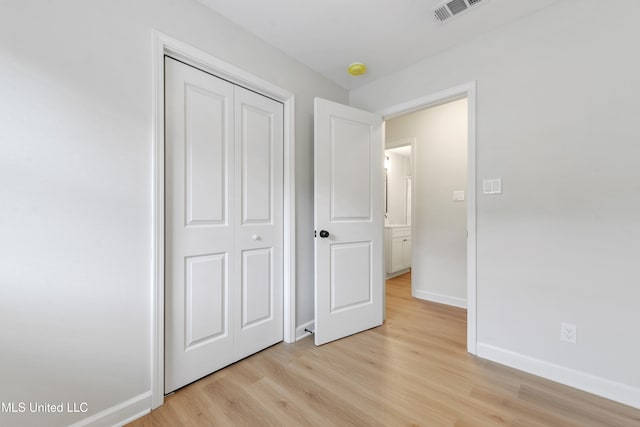 unfurnished bedroom featuring light hardwood / wood-style floors and a closet