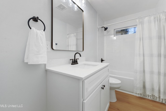 full bathroom featuring hardwood / wood-style floors, vanity, toilet, and shower / tub combo