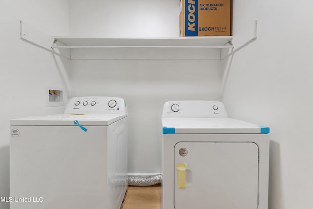 laundry room with hardwood / wood-style flooring and washer and dryer