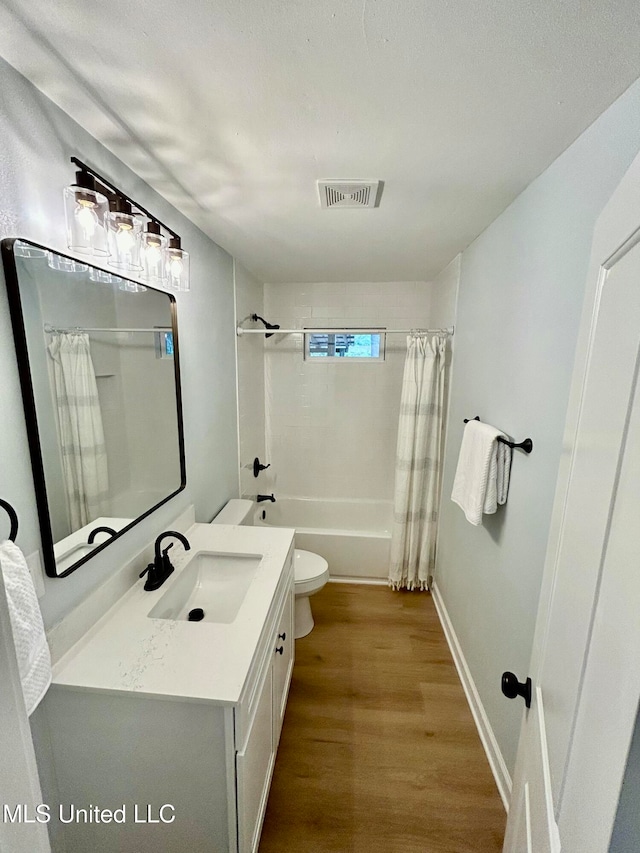 full bathroom with shower / bath combo, hardwood / wood-style floors, vanity, and toilet