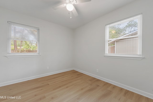 spare room with light wood-type flooring, ceiling fan, and plenty of natural light