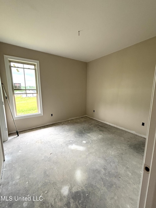 unfurnished room with unfinished concrete floors