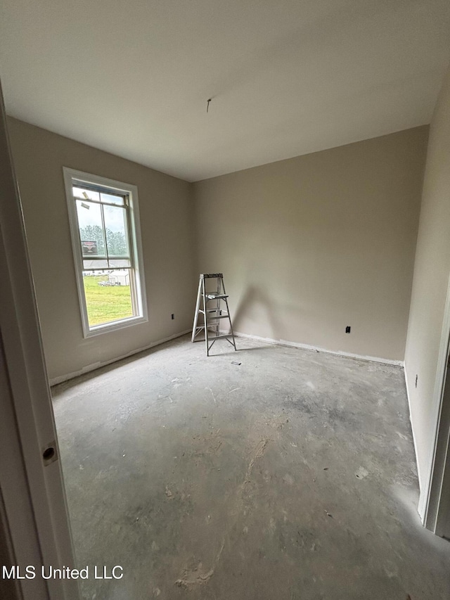 unfurnished room featuring concrete floors