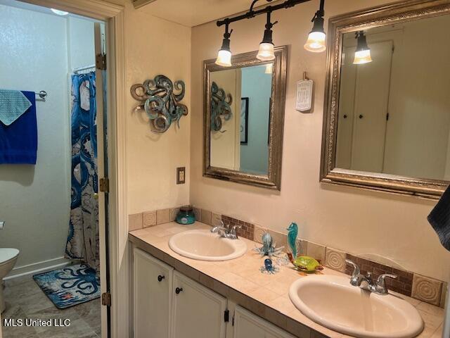 bathroom with tile patterned flooring, vanity, and toilet