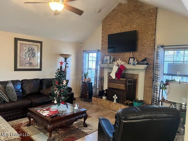 tiled living room featuring beamed ceiling, high vaulted ceiling, a brick fireplace, and ceiling fan