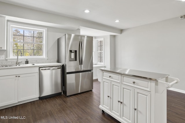 kitchen featuring dark wood-style flooring, a sink, light countertops, white cabinets, and appliances with stainless steel finishes