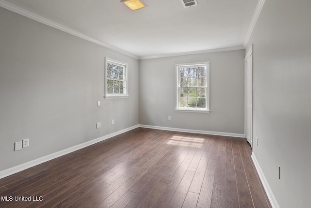 empty room featuring dark wood-type flooring, baseboards, and ornamental molding