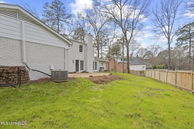 view of yard featuring central AC unit and fence