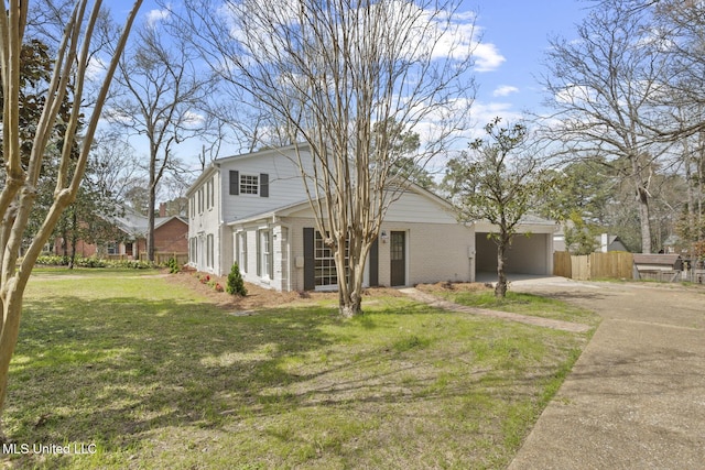 view of front facade featuring brick siding, an attached carport, a front lawn, fence, and driveway