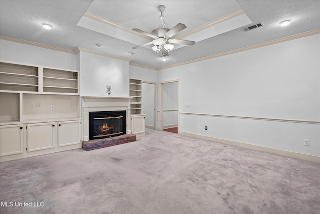 unfurnished living room featuring visible vents, a raised ceiling, light colored carpet, and a brick fireplace