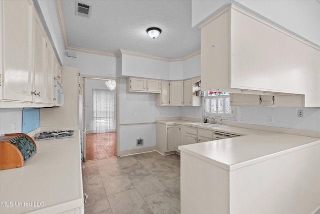 kitchen featuring ornamental molding, a sink, a peninsula, light countertops, and white microwave