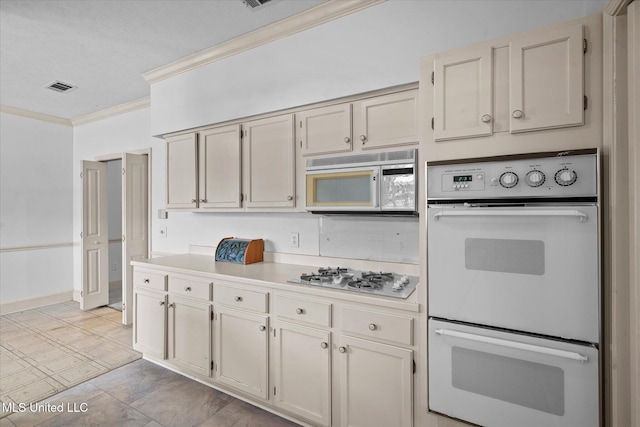 kitchen featuring visible vents, white appliances, light countertops, and crown molding